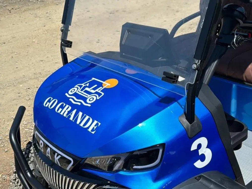 Close up of the Go Grande logo on the hood of a blue golf cart